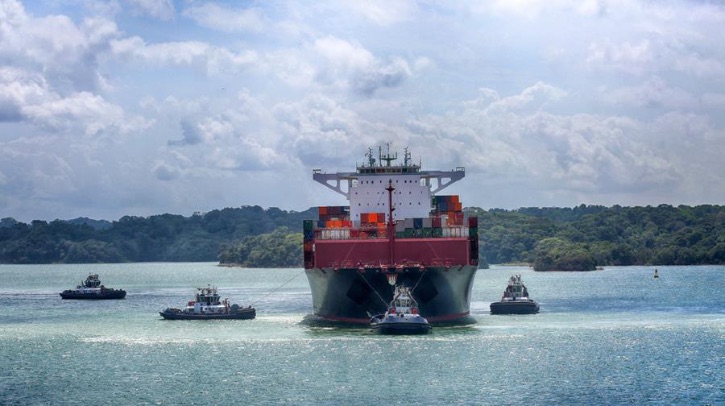 The Panama Canal Authority orders 10 hybrid-electric tractor tugboats Three tugboats flank a container ship near the Panama Canal.