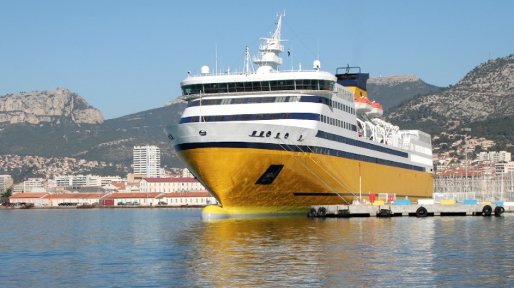 A yellow ocean liner docks at port.