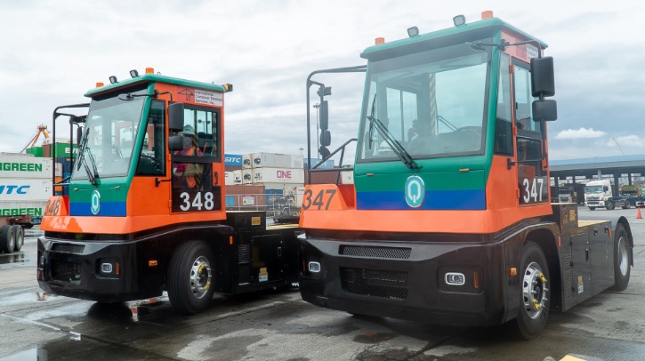 Two red EV terminal tractors sit parked side by side.