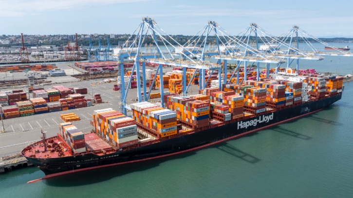 A large container ship docks at port.
