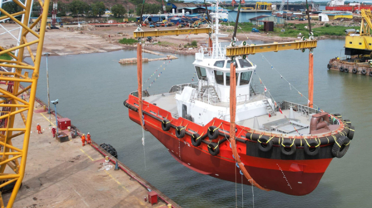 Singapore's red zero-emission E-Tug is lowered into the water.
