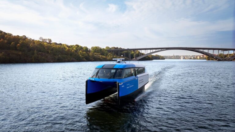 A Candela hydrofoil ferry sails across an inland waterway.