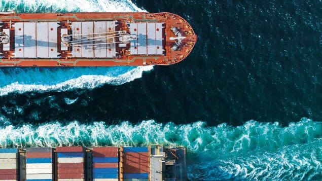Joint study shows path to green ammonia cost parity A screenshot from the cover of the joint report. It is an aerial shot of two container ships passing each other in green waters.