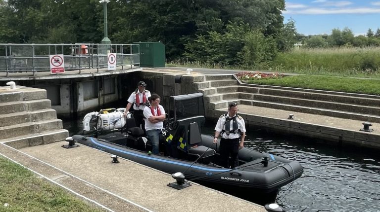 The UK Environment Agency's first zero-emission electric workboat Blackwater Joule, with three people stood on board.